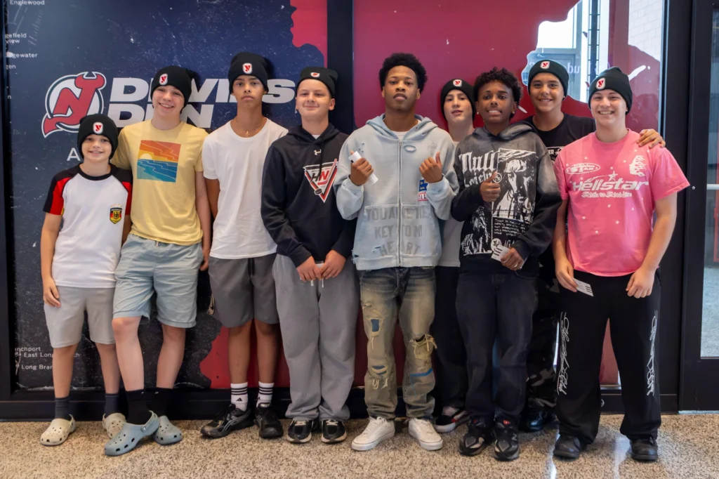 Hockey in New Jersey players in Devils Youth Foundation beanies pose with a fighter at the Matchroom Boxing press conference at Prudential Center
