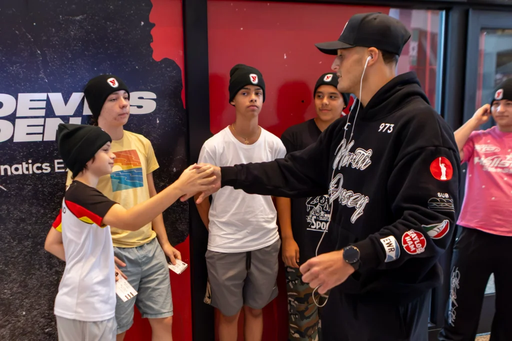 A fighter shakes hands with a young player outside the Devils Den at the Matchroom Boxing press conference at Prudential Center