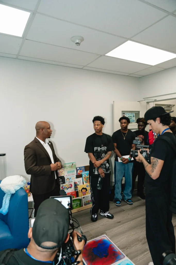 A club leader speaks with members in the Blue Room during Zaquin Moses's visit to the Boys & Girls Club of Newark